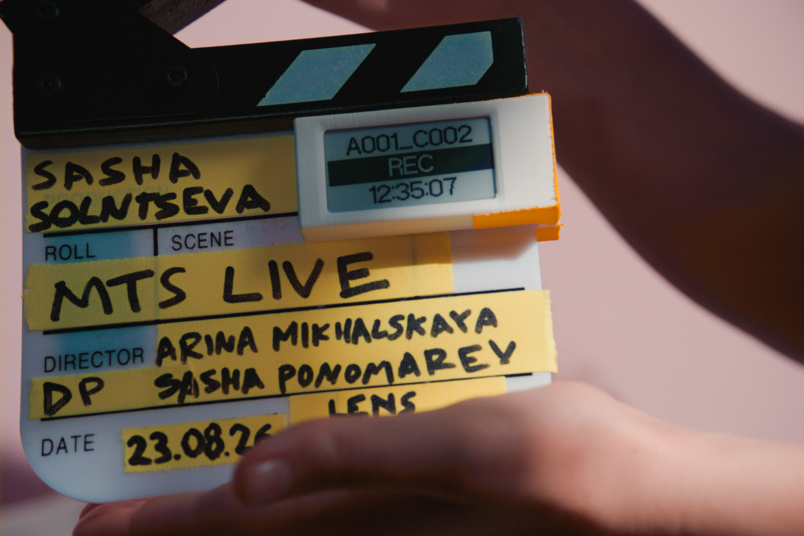 Cineink clipped to a film slate on set, showing A001_C002 / REC / 12:35:07 during a take